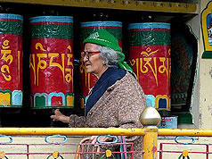 Old lady turning the praying wheels at Dharamsala